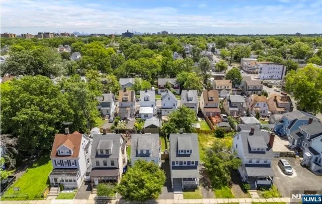 an aerial view of residential houses with outdoor space and trees