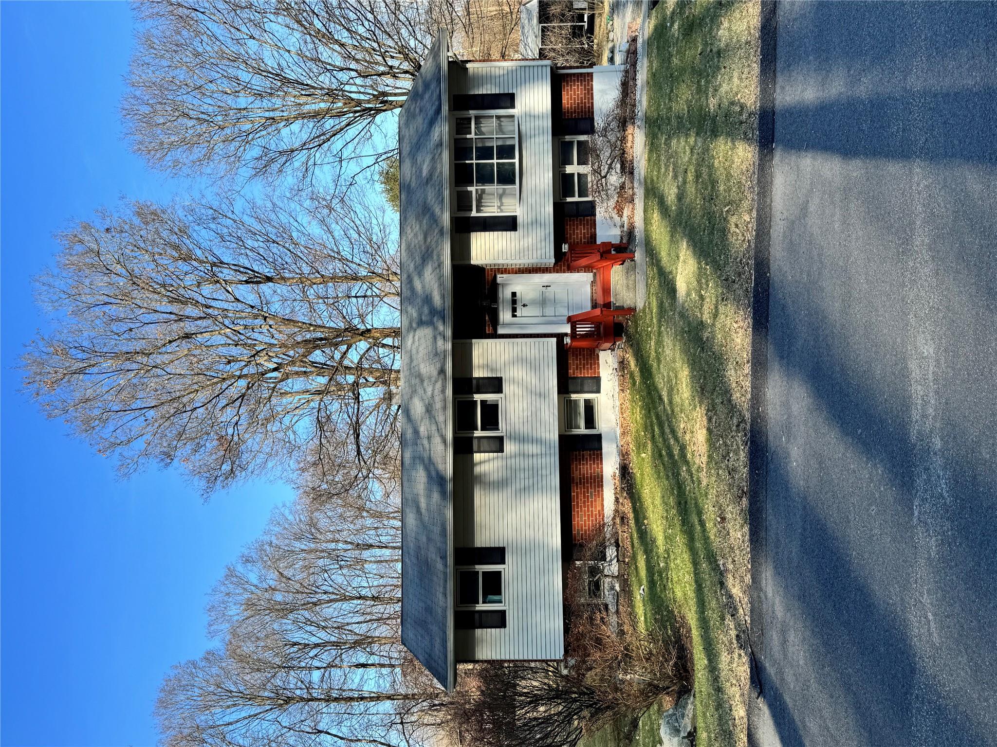 Split foyer home featuring brick siding, a front lawn, and entry steps