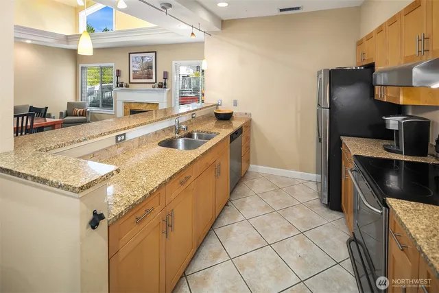 a kitchen with stainless steel appliances granite countertop a sink and a refrigerator