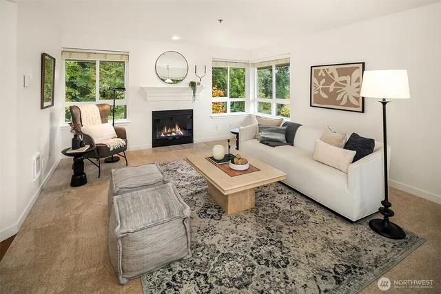 a living room with furniture a fireplace a lamp and a large window