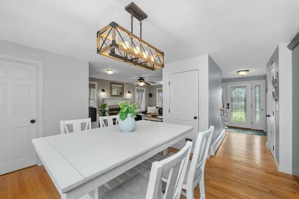 a view of a dining room and livingroom with furniture wooden floor a chandelier