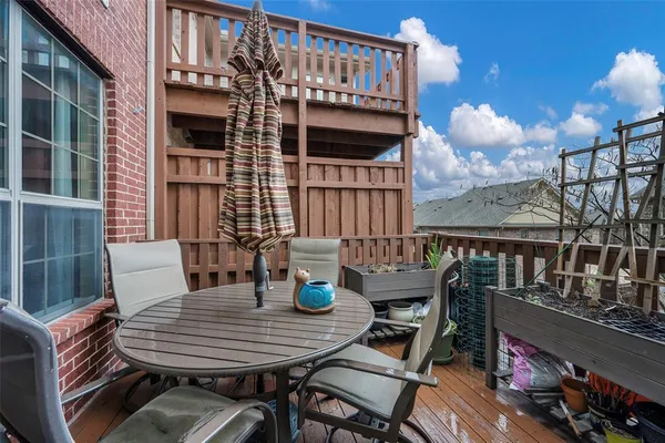 a view of a patio with dining table and chairs with wooden floor