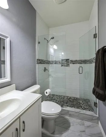 a bathroom with a sink a toilet and shower