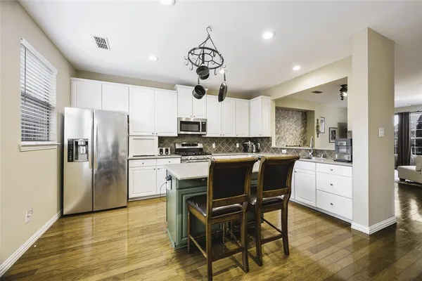 a kitchen with stainless steel appliances a refrigerator a stove microwave cabinets a sink dishwasher and a refrigerator