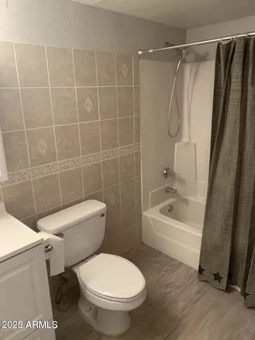 a white toilet sitting next to a bath tub and a shower