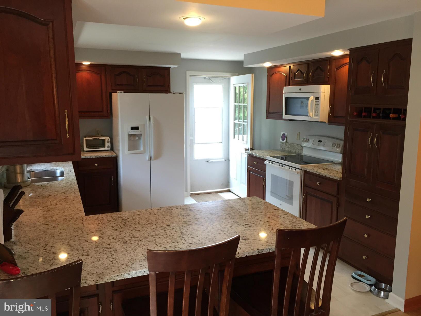 539 Turner Road Shepherdstown, WV 25443 - Photo 14 of 29 a kitchen with stainless steel appliances granite countertop a stove refrigerator a sink a dining table and chairs