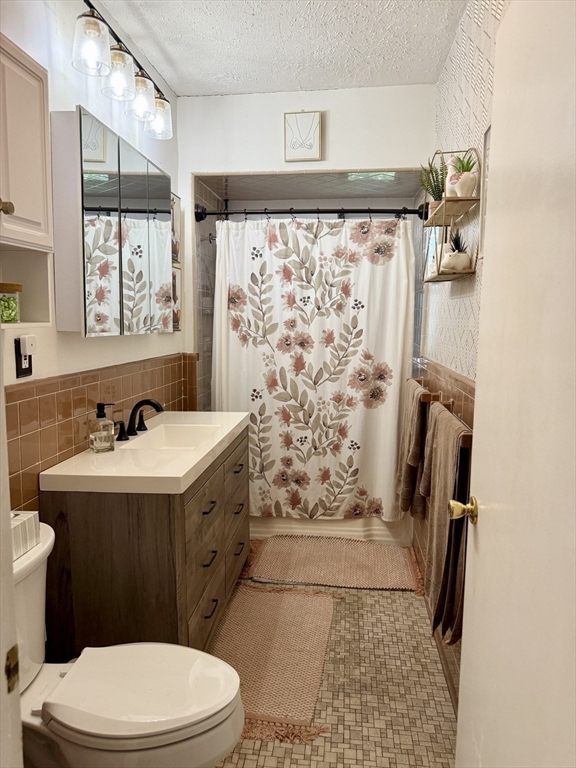 26 Forrest Street, Unit 3 Winthrop, MA 02152 - Photo 9 of 21 a bathroom with a sink a toilet a mirror a vanity and shower