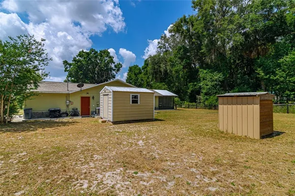 a view of a house with backyard and sitting area