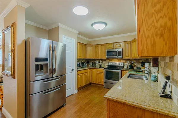 a view of a kitchen with a refrigerator and a sink