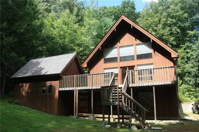 a view of house with backyard and deck