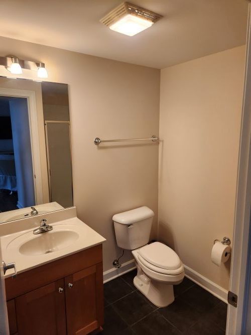 8440 Callie Avenue, Unit 410 Morton Grove, IL 60053 - Photo 13 of 27 a bathroom with a toilet a sink and mirror