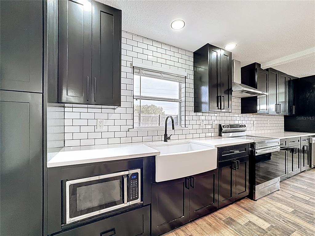 1890 Tyner Road Haines City, FL 33844 - Photo 15 of 48 a kitchen with stainless steel appliances a sink stove and cabinets