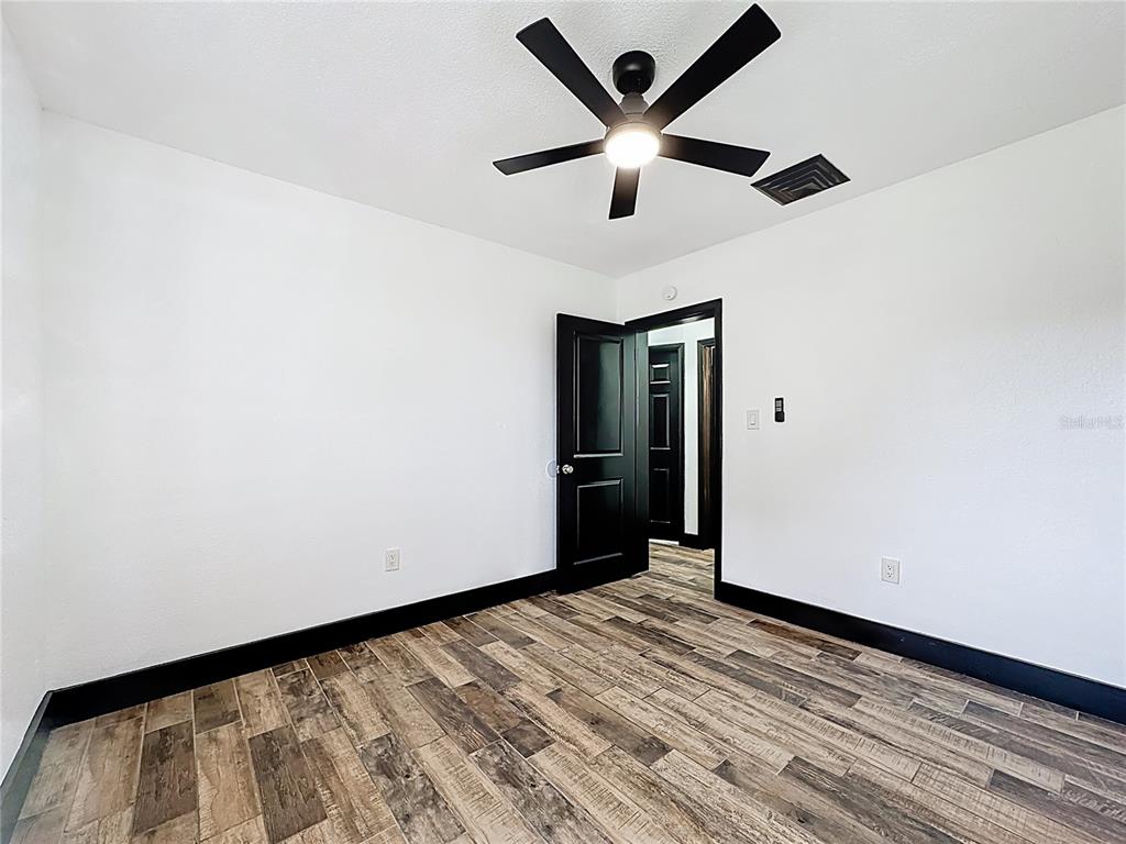 1890 Tyner Road Haines City, FL 33844 - Photo 29 of 48 an empty room with a ceiling fan and wooden floor