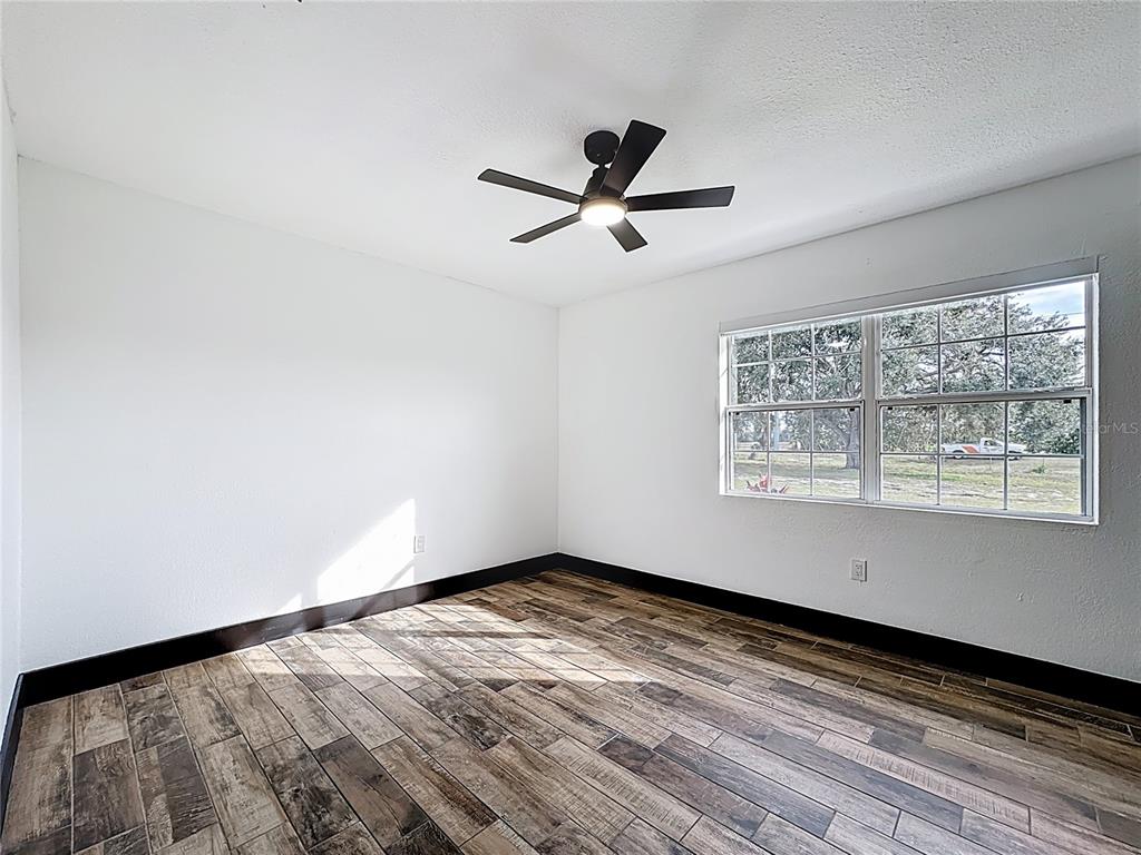 1890 Tyner Road Haines City, FL 33844 - Photo 31 of 48 a view of empty room with wooden floor and fan
