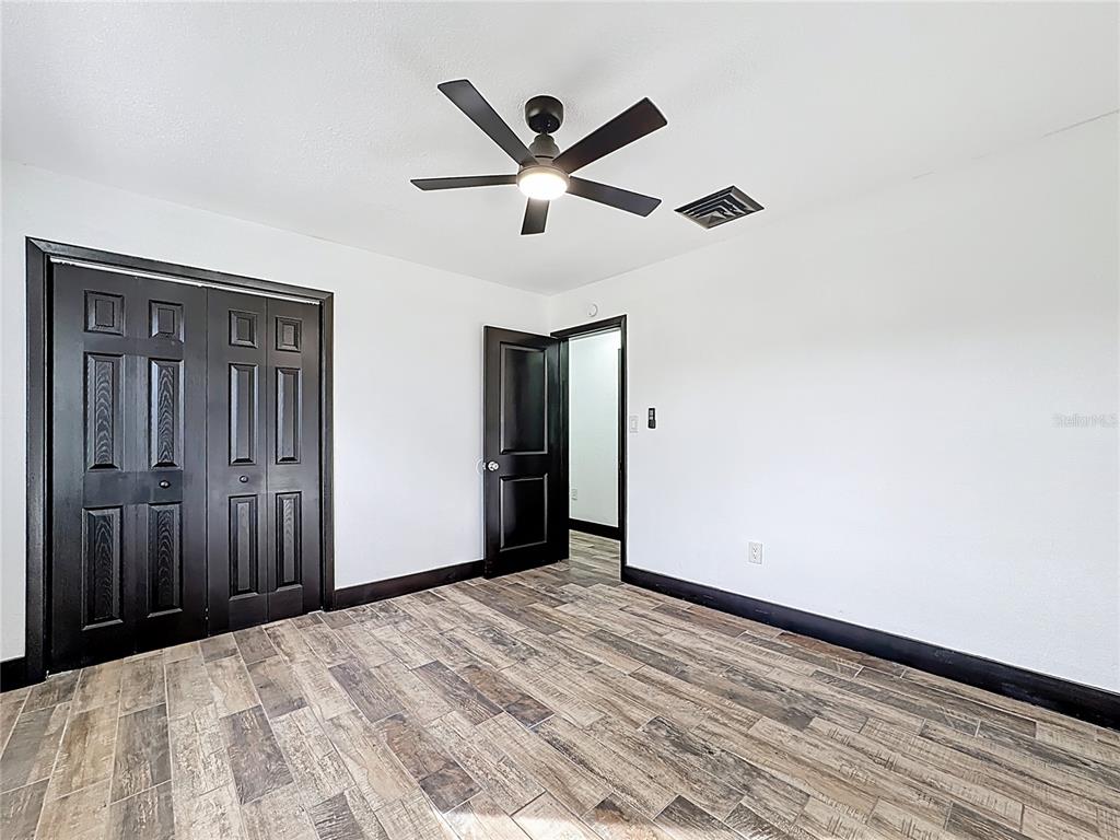 1890 Tyner Road Haines City, FL 33844 - Photo 32 of 48 a view of empty room with wooden floor and ceiling fan