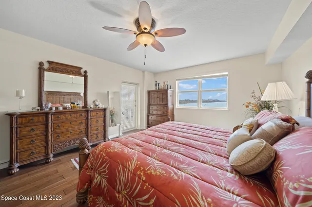 a bedroom with a bed and dresser with mirror