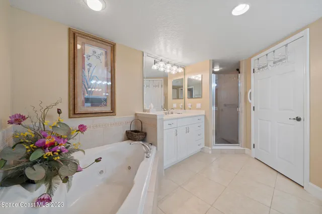 a bathroom with a tub sink mirror and vanity