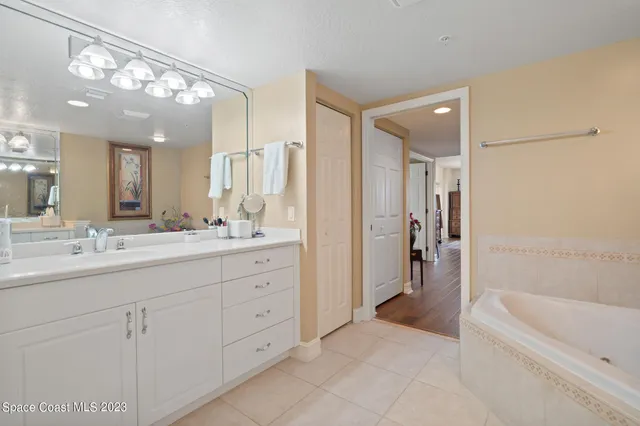 a bathroom with a tub a sink shower and mirror