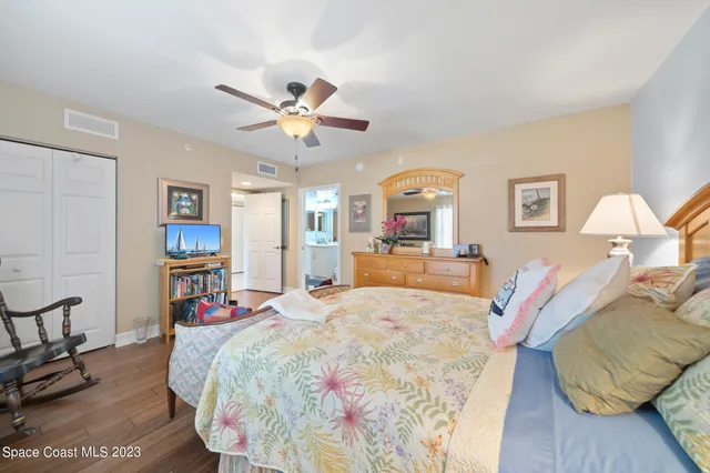 a bed room with a bed mirror and a chair