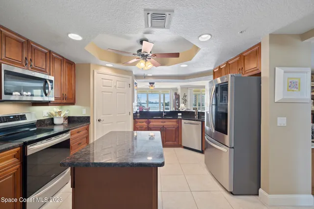 a kitchen with stainless steel appliances granite countertop a refrigerator a stove a sink and a microwave