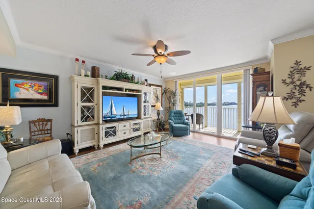 a living room with furniture and a flat screen tv with wooden floor