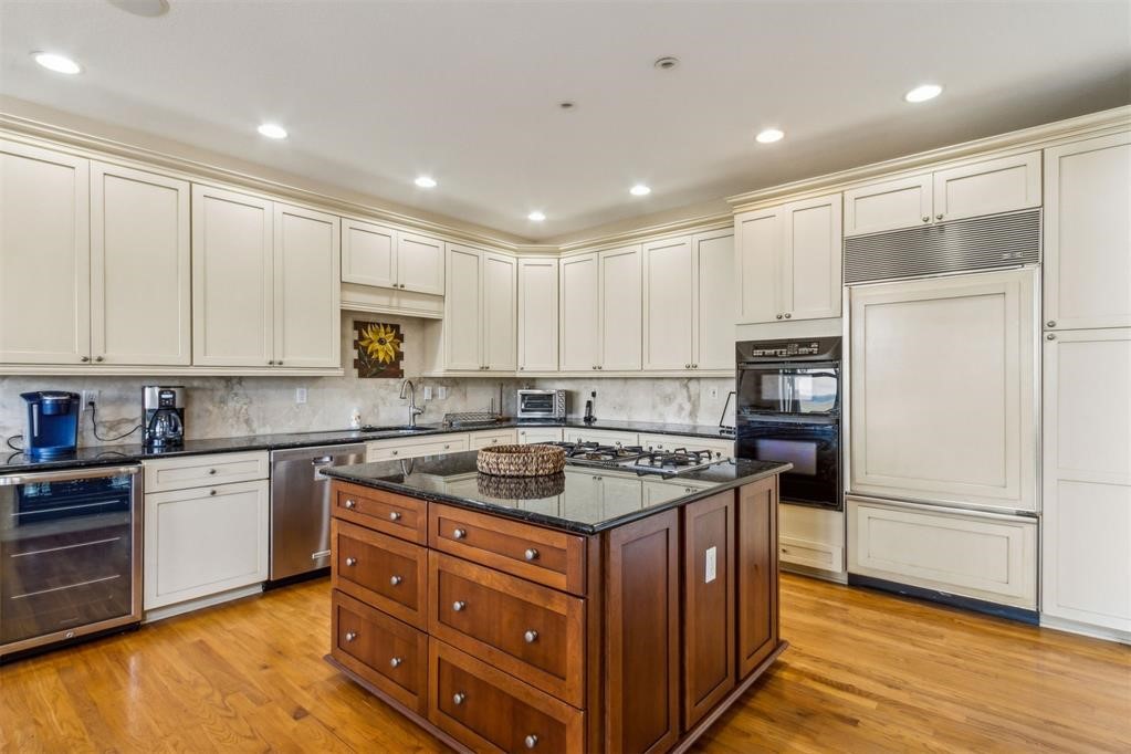3119 Sea Marsh Road Fernandina Beach, FL 32034 - Photo 13 of 41 a kitchen with stainless steel appliances granite countertop a stove a refrigerator and a sink with wooden cabinets