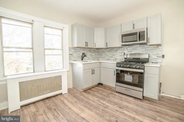 a kitchen with granite countertop a stove a sink and a microwave