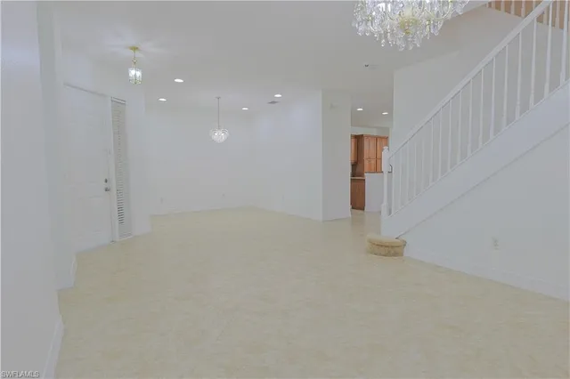 en empty room with chandelier and windows