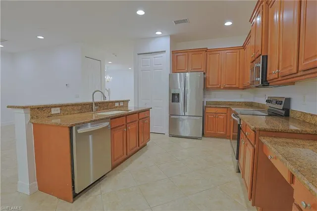 a kitchen with kitchen island sink refrigerator and cabinets