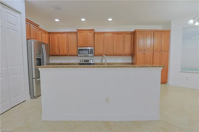 a view of kitchen with stainless steel appliances granite countertop cabinets and a refrigerator