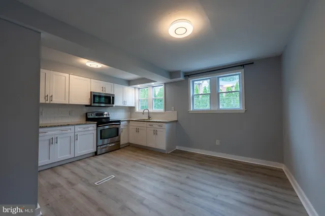 a kitchen with granite countertop a stove top oven sink and cabinets