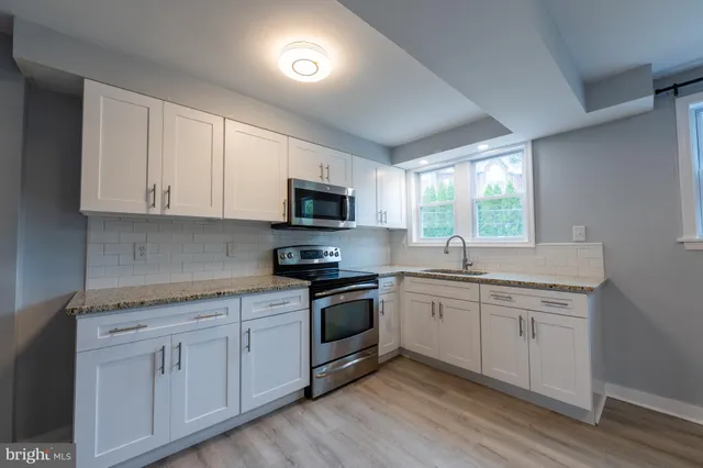 a kitchen with appliances a sink and cabinets