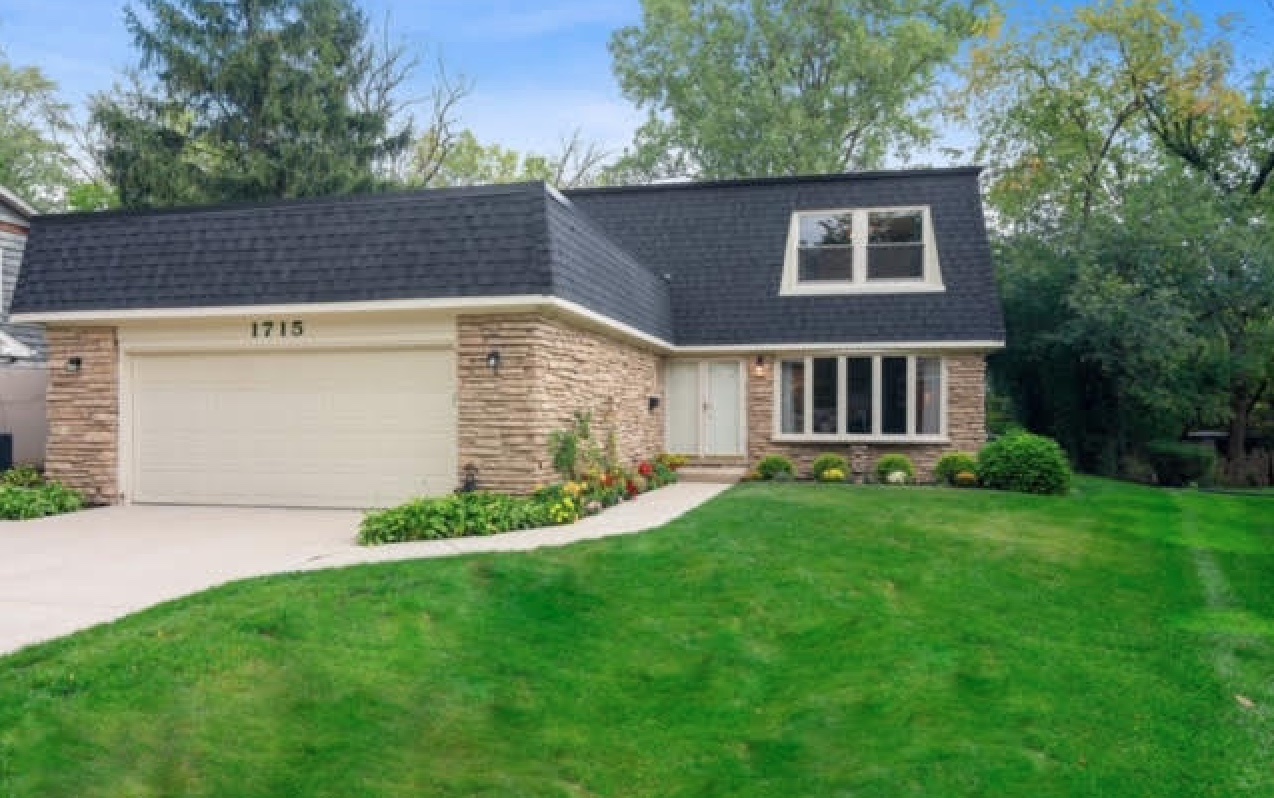 a front view of a house with a garden and yard