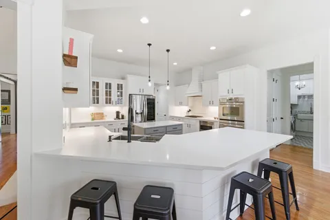 a large kitchen with cabinets a sink and stainless steel appliances