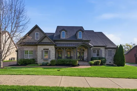 a front view of a house with a garden