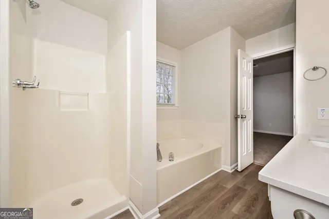 a bathroom with a tub shower and vanity