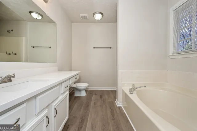 a bathroom with a granite countertop sink a toilet and bathtub