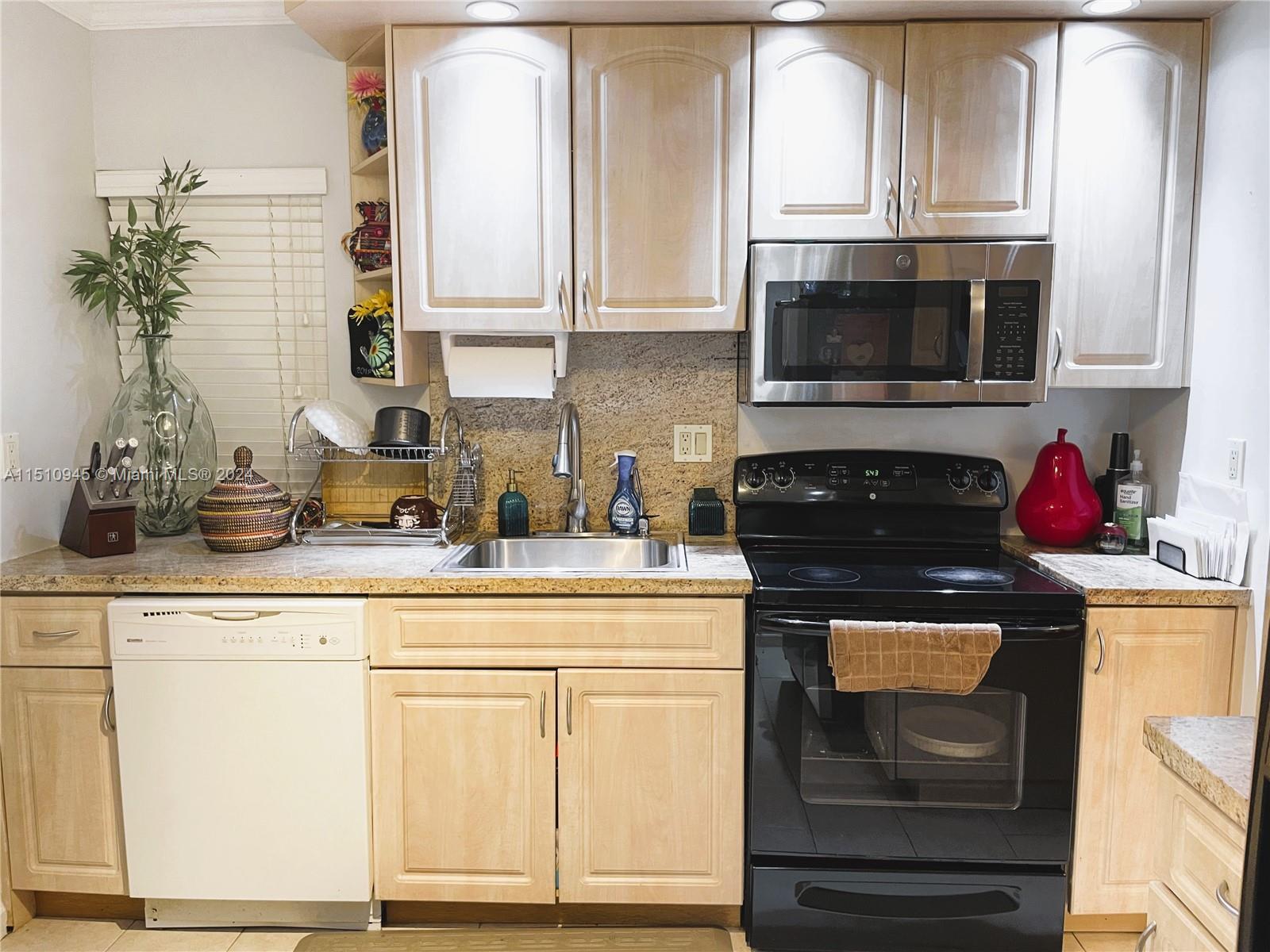 a kitchen with granite countertop white cabinets and stainless steel appliances
