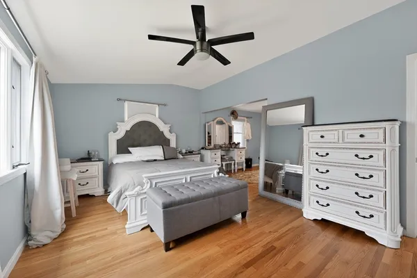 a bedroom with a bed and wooden floor