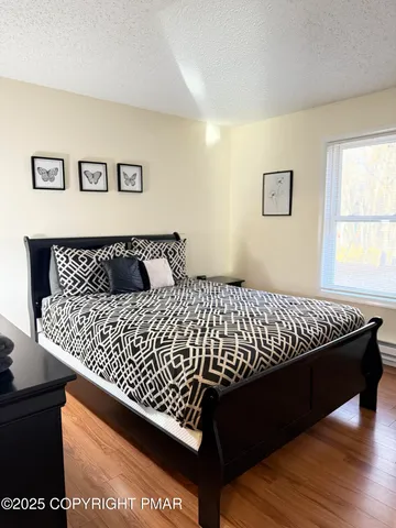 a bedroom with a bed and wooden floor