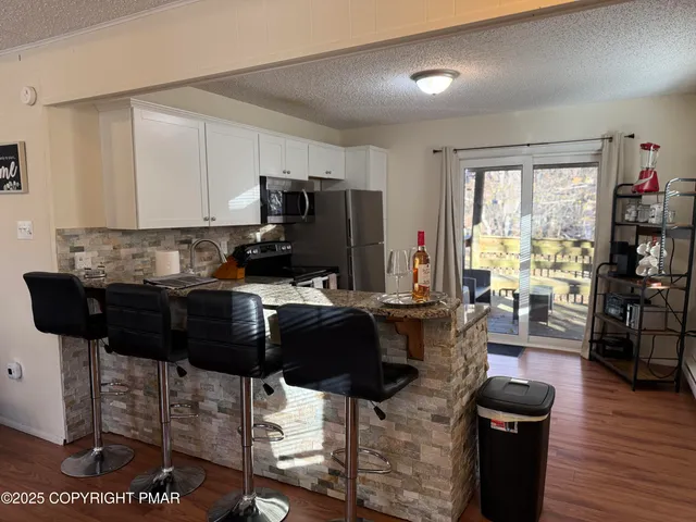 a living room with furniture a wooden floor and a large window