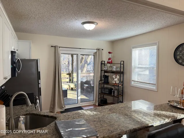 a kitchen with granite countertop a refrigerator and a sink