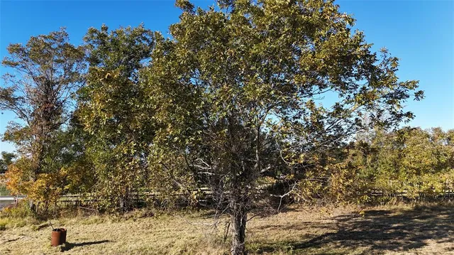 a view of swimming pool with lawn chairs and wooden fence