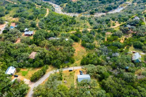 an aerial view of residential house with outdoor space and trees all around