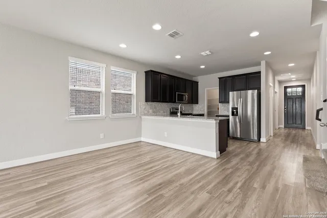 a view of kitchen with refrigerator microwave and stove top oven