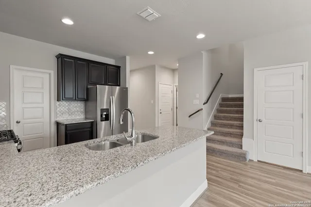 a kitchen with sink refrigerator and cabinets