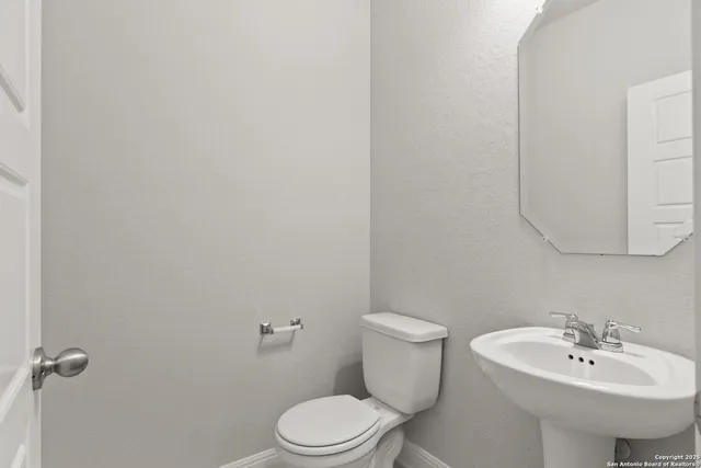 a bathroom with a sink a toilet and mirror