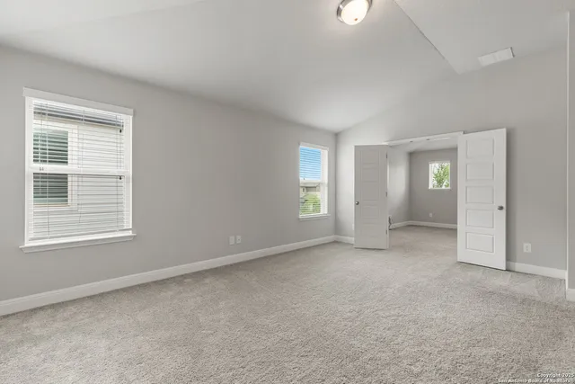 an empty room with windows and closet