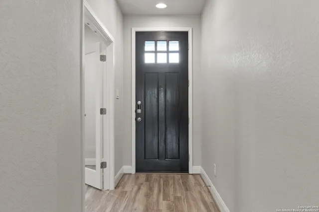 a view of a hallway with wooden floor