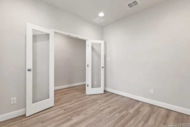 an empty room with wooden floor & door